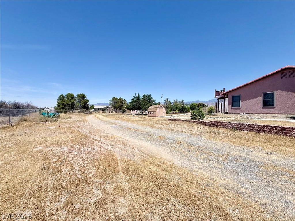 1220 East Gamebird Road Pahrump, NV 89048 - Photo 21 of 49 Discover a spacious property featuring a long gravel driveway and distant mountain vistas.