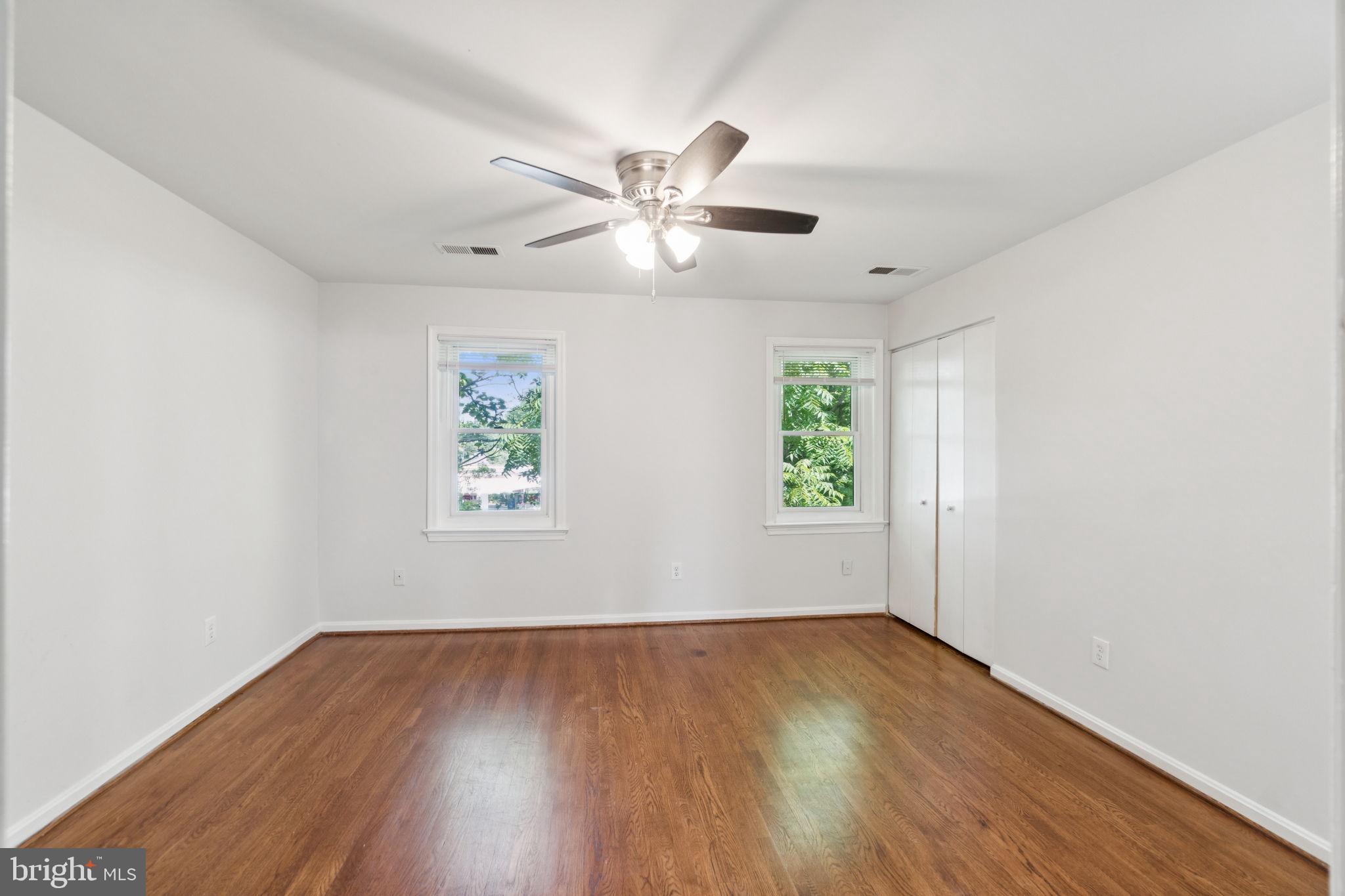 6711 Washington Boulevard, Unit C Arlington, VA 22205 - Photo 18 of 30 an empty room with wooden floor ceiling fan and windows