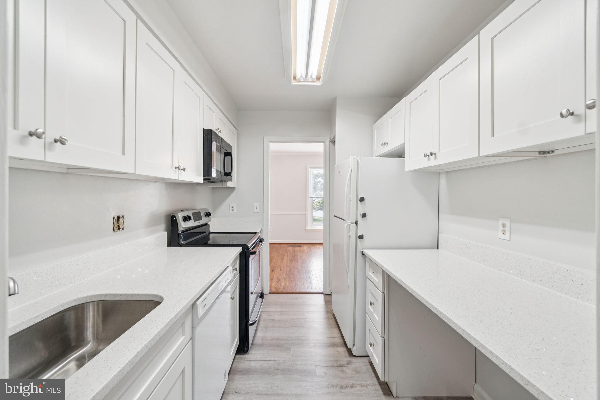 6711 Washington Boulevard, Unit C Arlington, VA 22205 - Photo 2 of 30 a kitchen with white cabinets sink and white appliances
