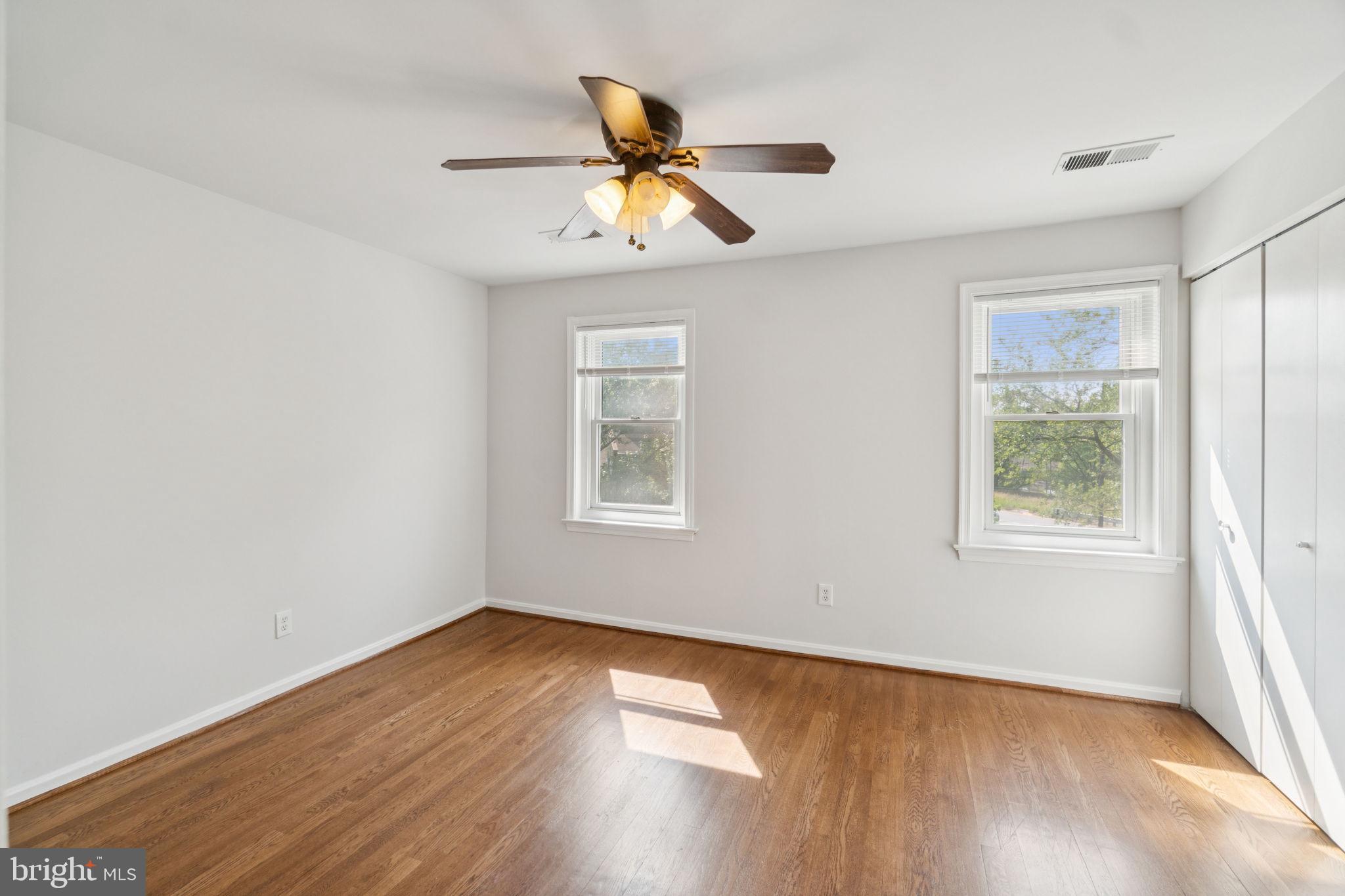 6711 Washington Boulevard, Unit C Arlington, VA 22205 - Photo 24 of 30 an empty room with wooden floor fan and windows