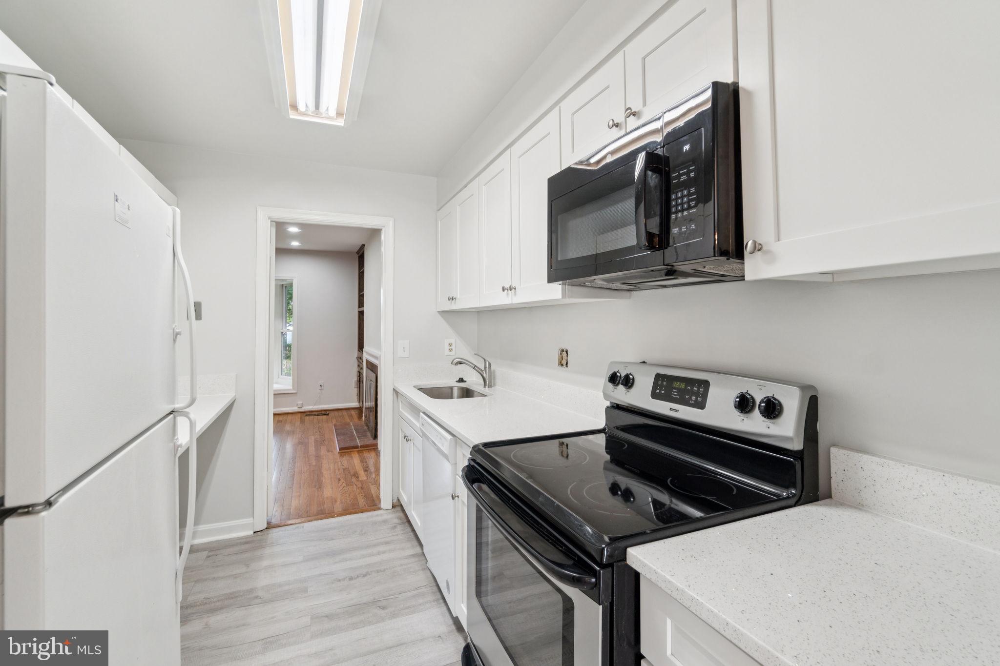 6711 Washington Boulevard, Unit C Arlington, VA 22205 - Photo 3 of 30 a kitchen with a stove and a microwave
