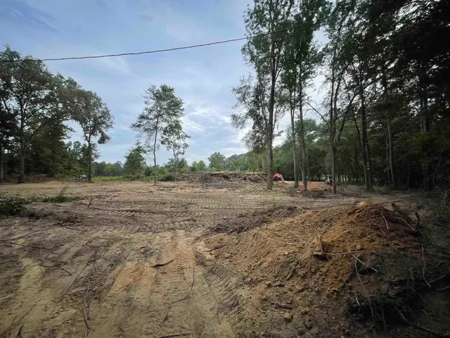a view of a yard with wooden fence