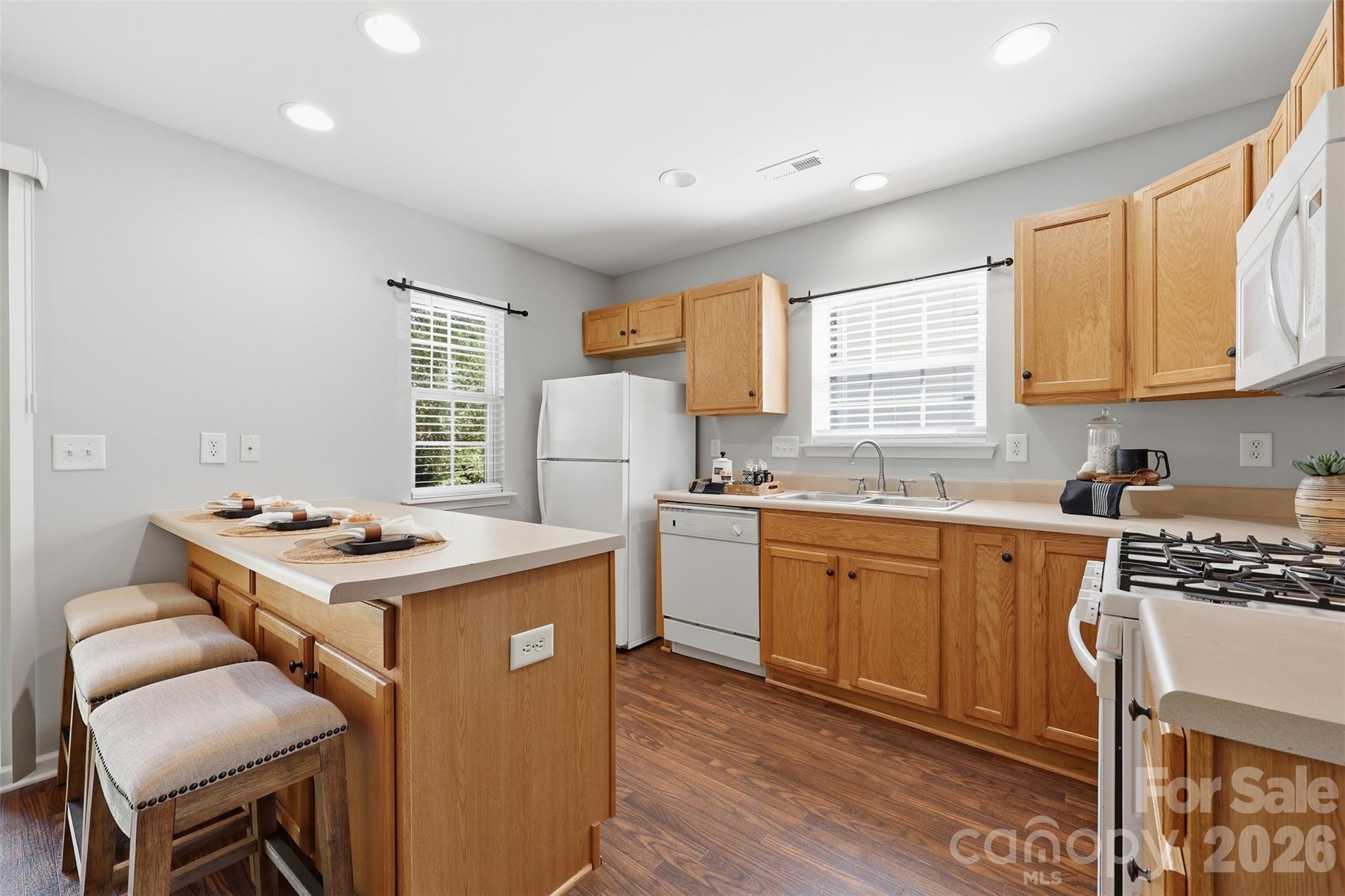 212 Primrose Walk Fort Mill, SC 29715 - Photo 7 of 37 a kitchen with a stove a sink a refrigerator wooden floor and cabinets