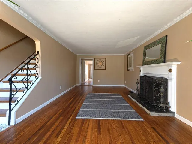 a view of a livingroom with wooden floor and a fireplace