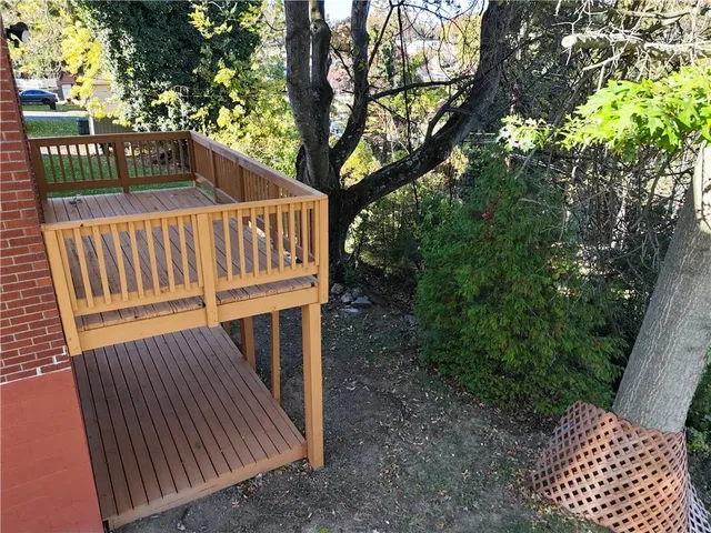 a view of balcony with wooden fence and trees