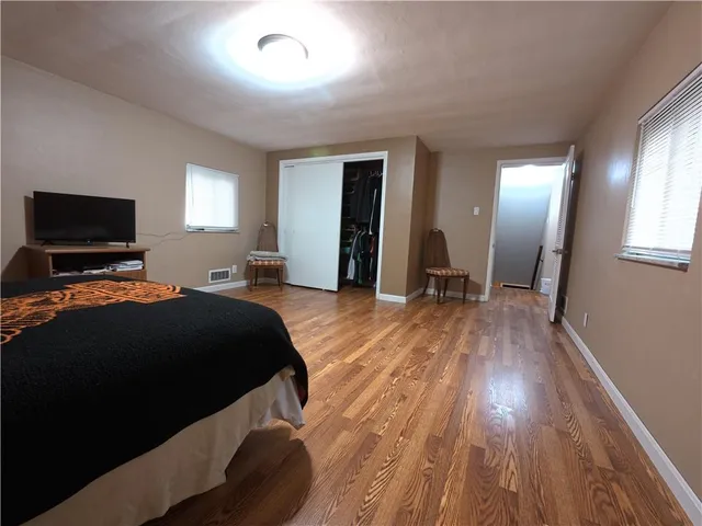 a bedroom with a bed and wooden floor