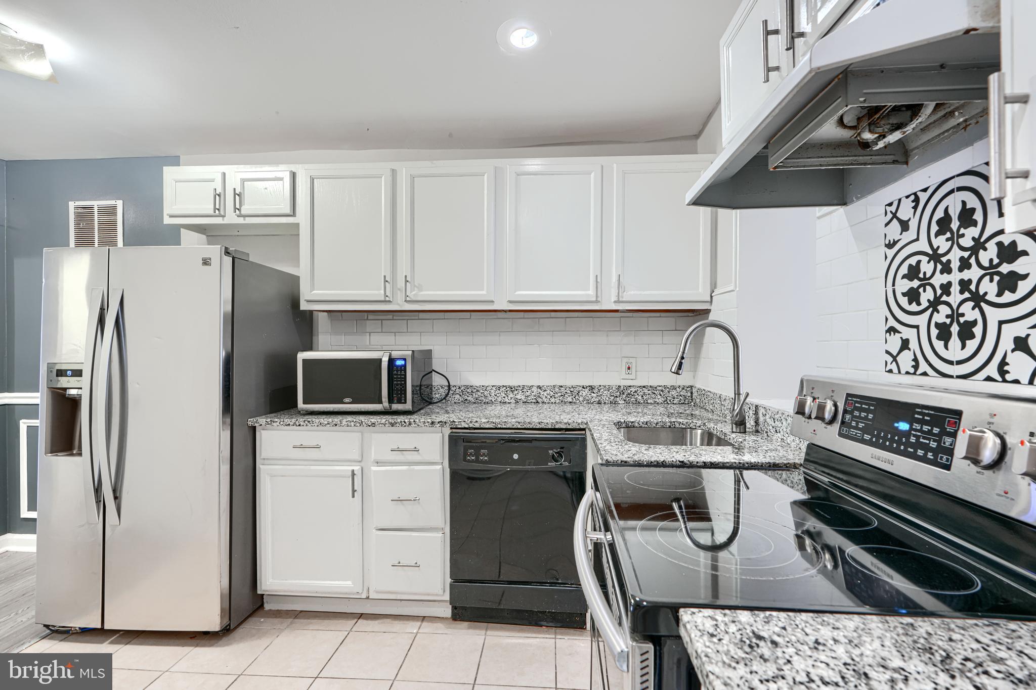 1127 Sargeant Street Baltimore, MD 21223 - Photo 11 of 30 a kitchen with stainless steel appliances granite countertop a stove a refrigerator and a sink