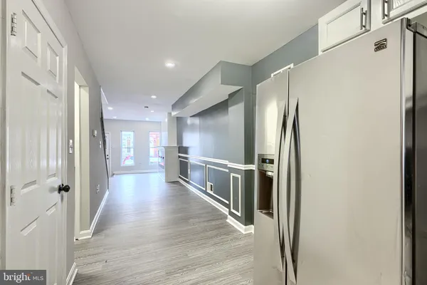 a hallway with wooden floor and staircase
