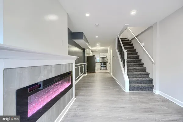 a hallway with wooden floor and stairs