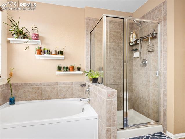 5346 Gentle Wind Road Colorado Springs, CO 80922 - Photo 24 of 28 Full bath with a shower stall and a garden tub