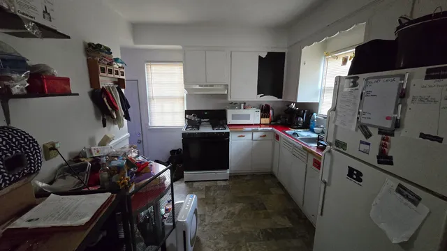 a kitchen with refrigerator and cabinets