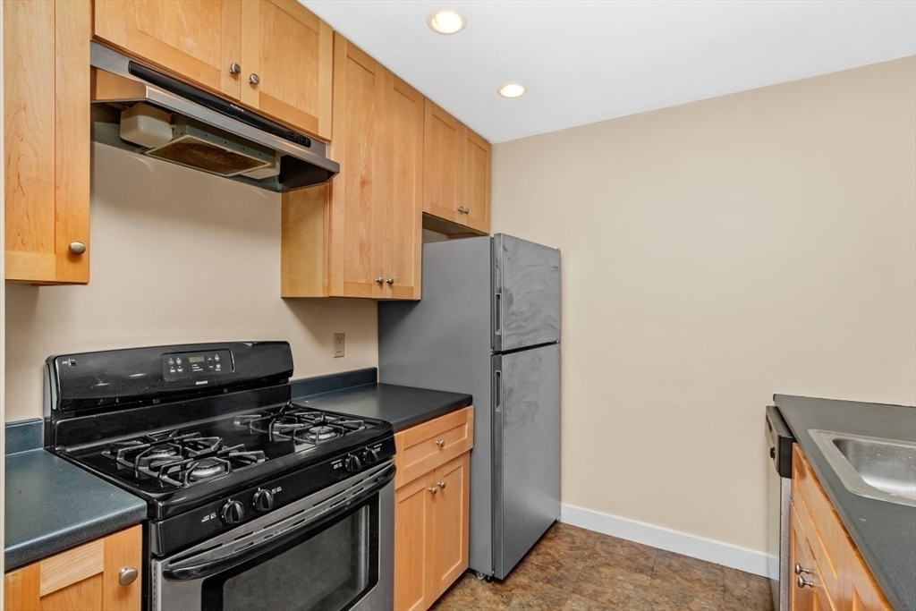 296 Meridian Street, Unit 2 Boston, MA 02128 - Photo 6 of 11 a kitchen with stainless steel appliances granite countertop a stove and a refrigerator