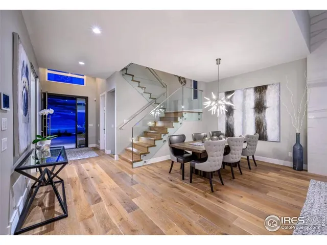 a living room with furniture dining table a large window and wooden floor