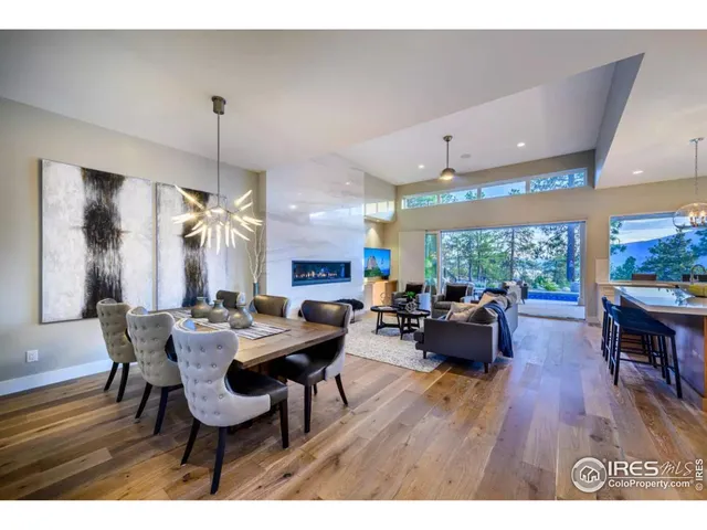 a living room with furniture kitchen view and a wooden floor