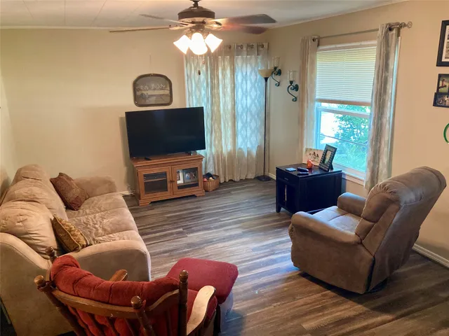a living room with furniture a flat screen tv and a window
