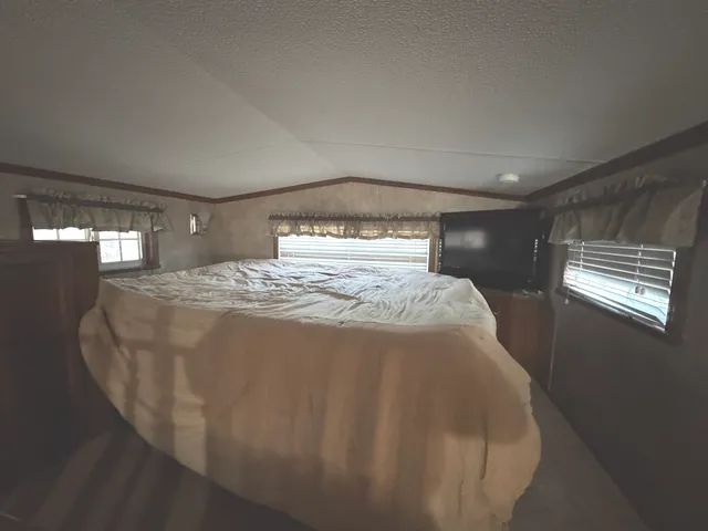 a bed sitting in a bedroom next to a window