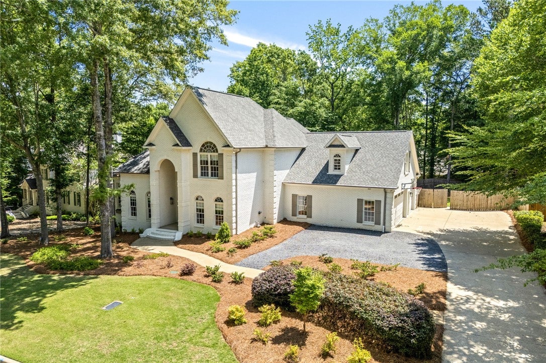 1657 Abby Road Auburn, AL 36830 - Photo 2 of 39 This classic white brick home boasts a lush green lawn and mature trees, offering a private oasis.