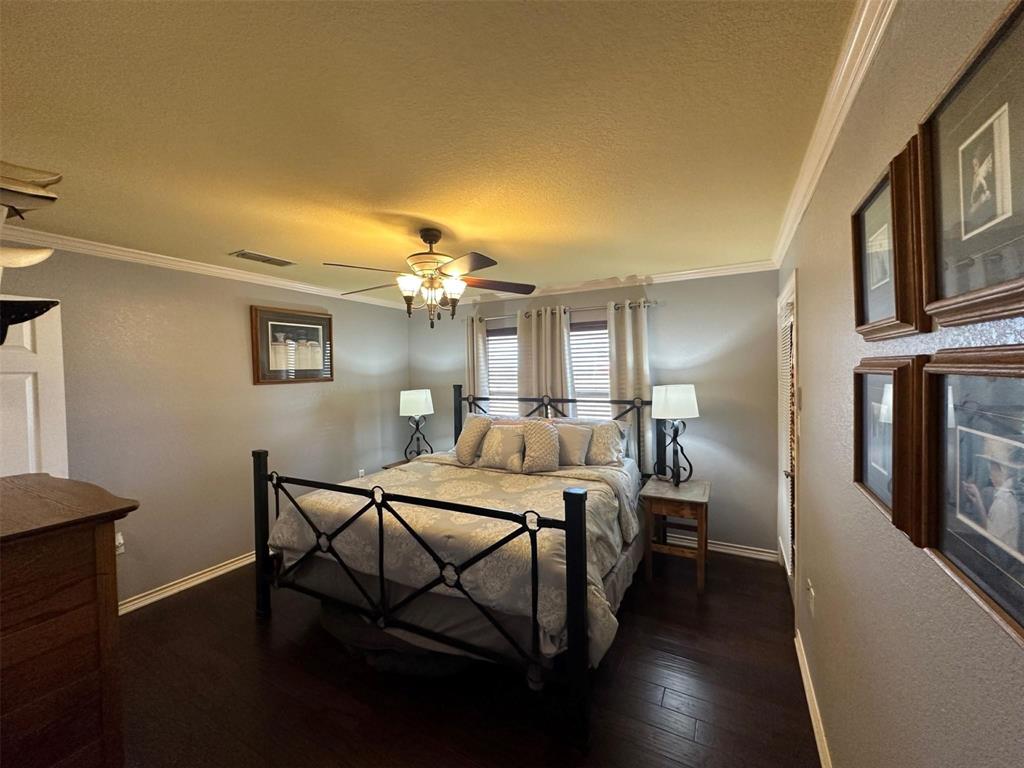 2901 Wind Mill Court Tolar, TX 76476 - Photo 11 of 38 a bedroom with a bed table closet and wooden floor