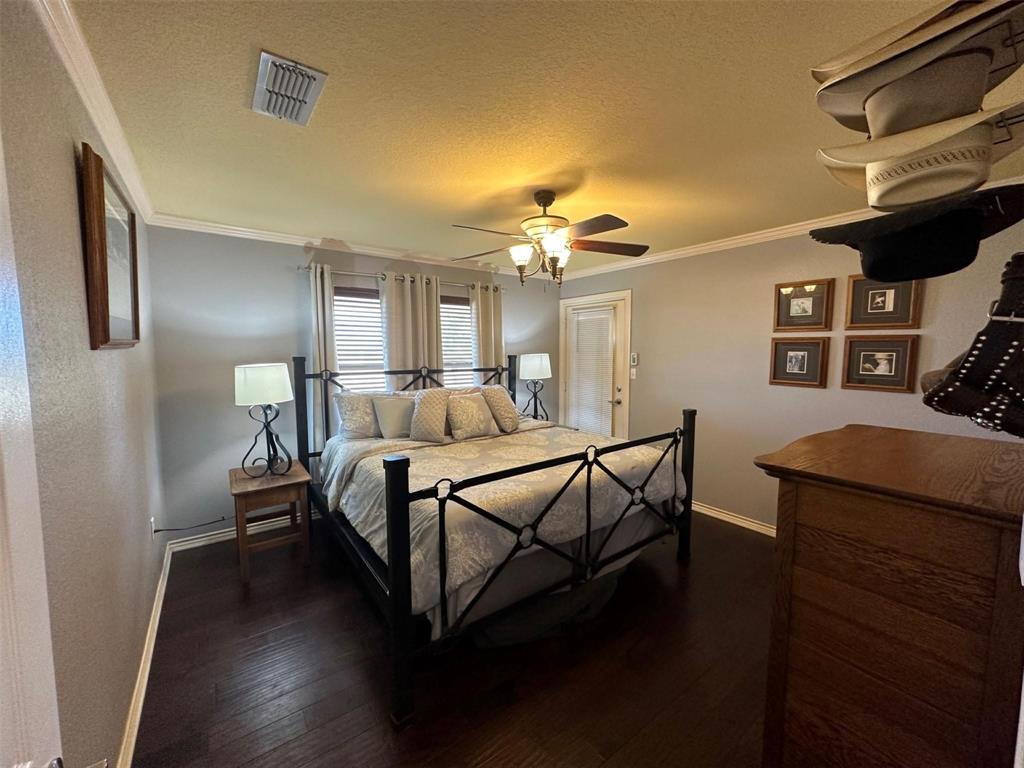 2901 Wind Mill Court Tolar, TX 76476 - Photo 12 of 38 a bedroom with a bed and a chandelier