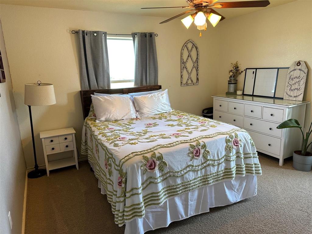 2901 Wind Mill Court Tolar, TX 76476 - Photo 16 of 38 a bedroom with a bed and a chandelier