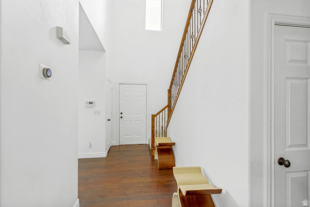 1585 South 910 West Payson, UT 84651 - Photo 6 of 32 Two-story entryway featuring high ceilings, wood-finish flooring, a staircase with wrought iron balusters and wood handrails, and a modern thermostat