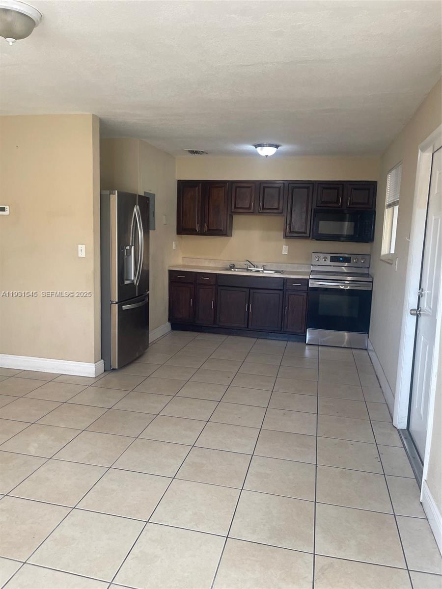 3031 Northwest 134th Street, Unit 1 Opa-Locka, FL 33054 - Photo 3 of 8 a large bathroom with a sink and a large mirror