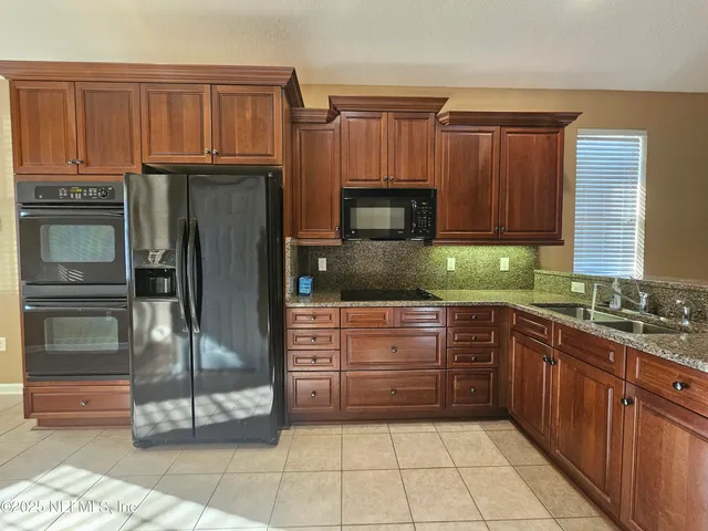 a kitchen with granite countertop a refrigerator and a sink