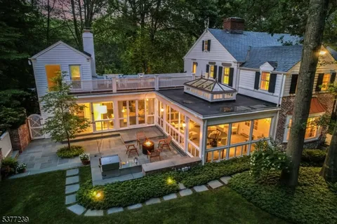 an aerial view of a house with swimming pool next to a yard