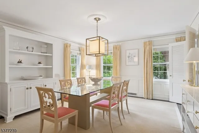 a dining room with furniture a chandelier and wooden floor