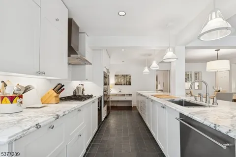 a kitchen with sink stove top oven and cabinets