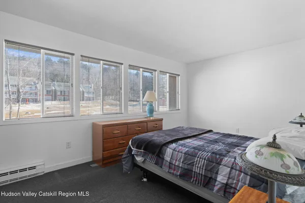a bedroom with a bed and a large window