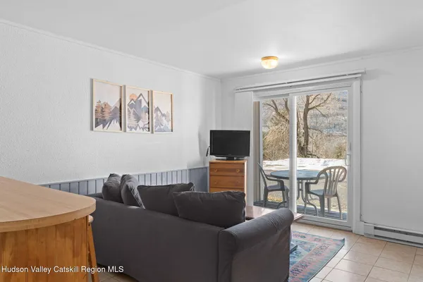 a living room with furniture a refrigerator and a couch