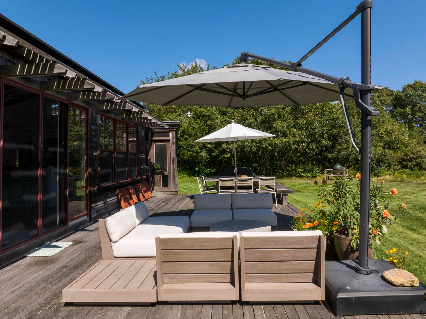 65 Carl's Way West Tisbury, MA 02568 - Photo 23 of 25 a view of a patio with couches table and chairs under an umbrella