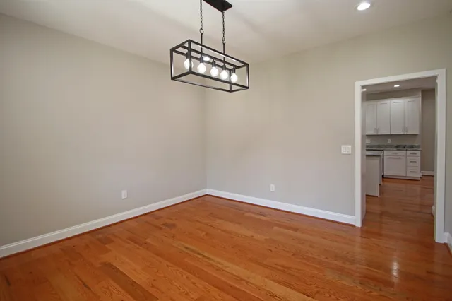 a view of an empty room with wooden floor and closet