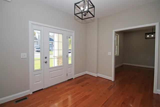 a view of a dining room with furniture wooden floor and a chandelier