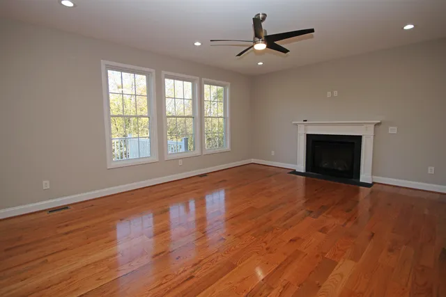 a balcony with wooden floor and trees in the background