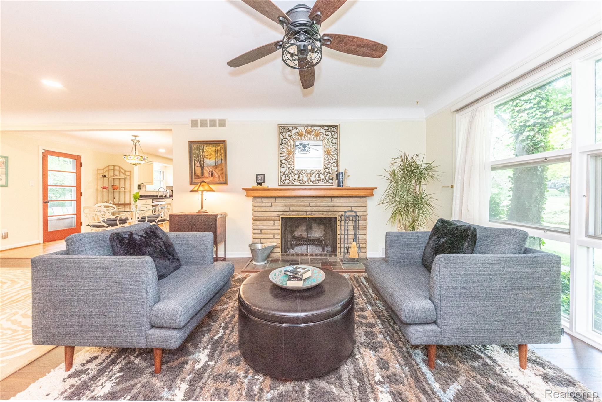 3887 Stonecrest Road West Bloomfield, MI 48322 - Photo 29 of 45 Living area featuring a stone fireplace with a wood mantel, crown molding, and wood-finish flooring