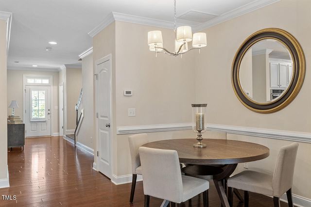 a view of a dining room with furniture a chandelier and wooden floor