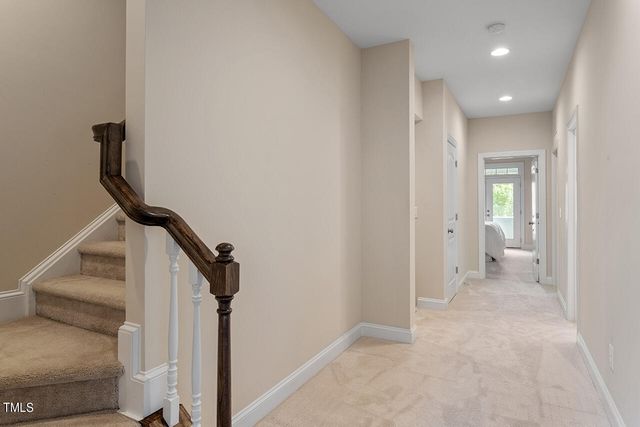 a view of a hallway with white walls and stairs
