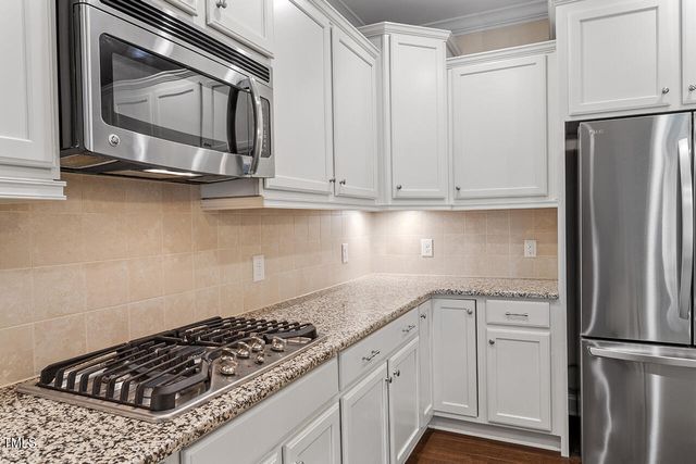a kitchen with granite countertop a sink stove and refrigerator