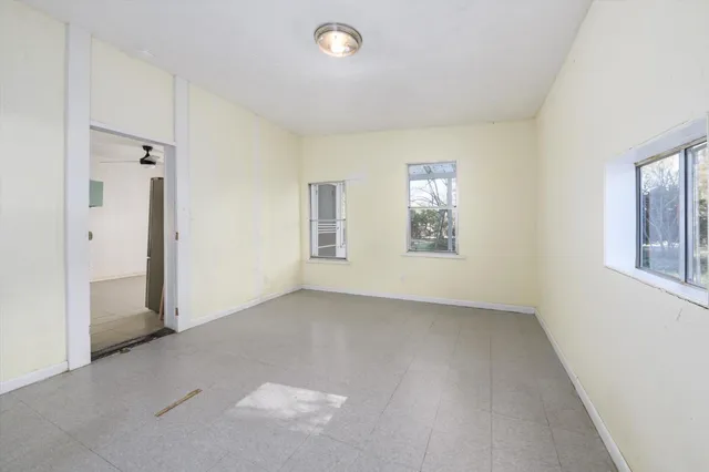 an empty room with windows and closet