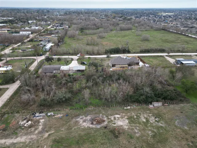an aerial view of residential houses with outdoor space and trees