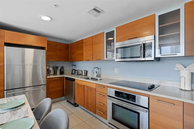 a kitchen with stainless steel appliances granite countertop a refrigerator stove microwave and sink