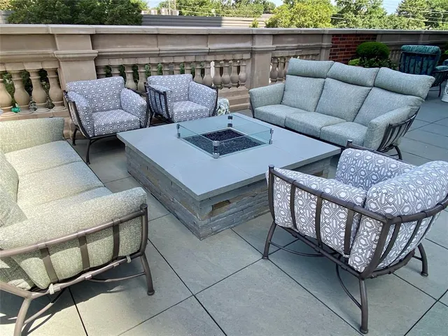 a view of a terrace with lawn chairs and potted plants