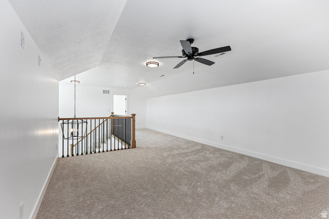 1144 South 4475 West West Point, UT 84015 - Photo 20 of 30 Spacious carpeted room featuring an open stairwell with black metal balusters and a dark wood handrail