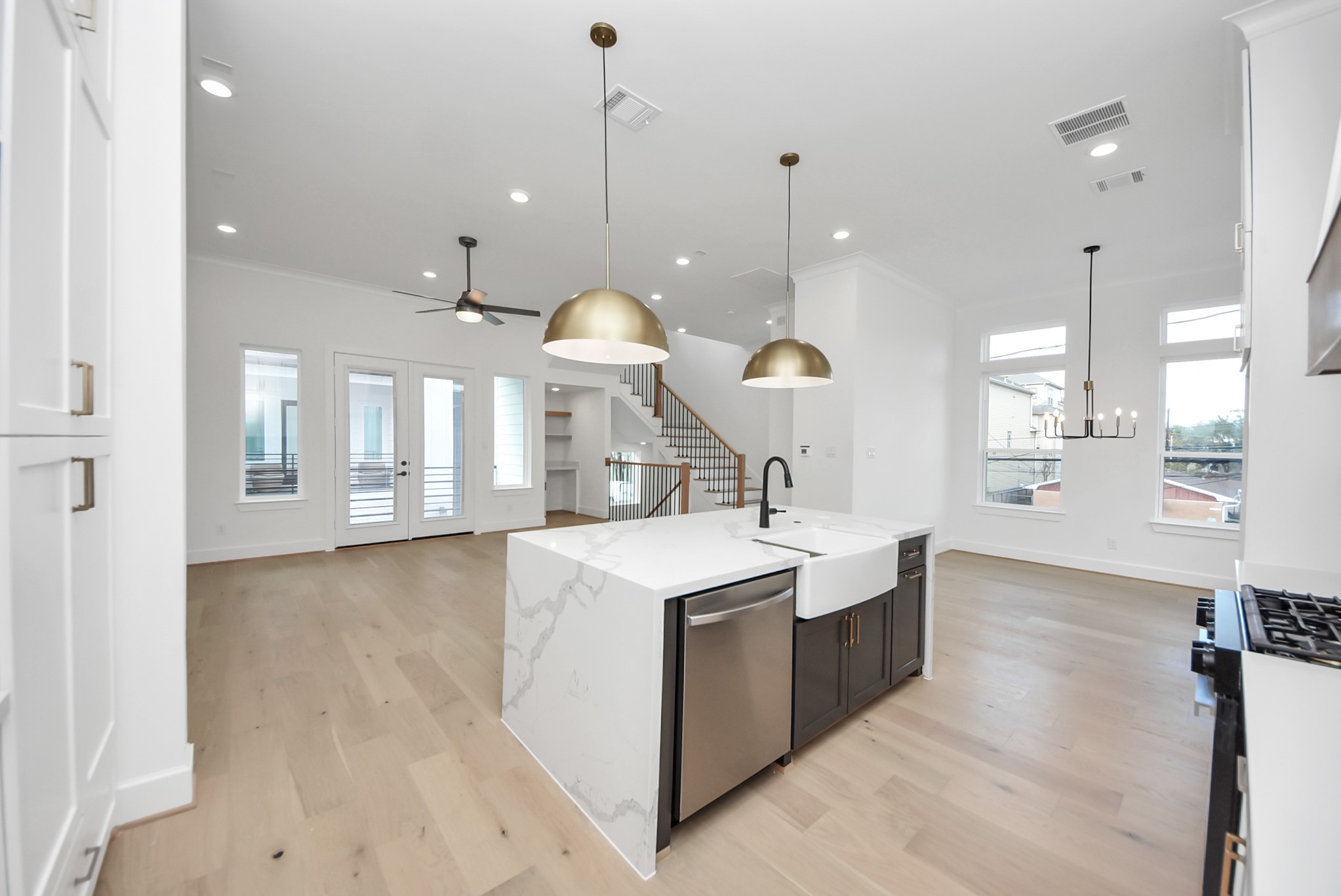 923 Fisher Street, Unit A Houston, TX 77018 - Photo 11 of 47 A contemporary open-concept living space anchored by a bright kitchen with a generous island, stylish pendant lighting, and stainless steel appliances. High ceilings, large windows, and hardwood floors enhance the sense of openness and comfort throughout.