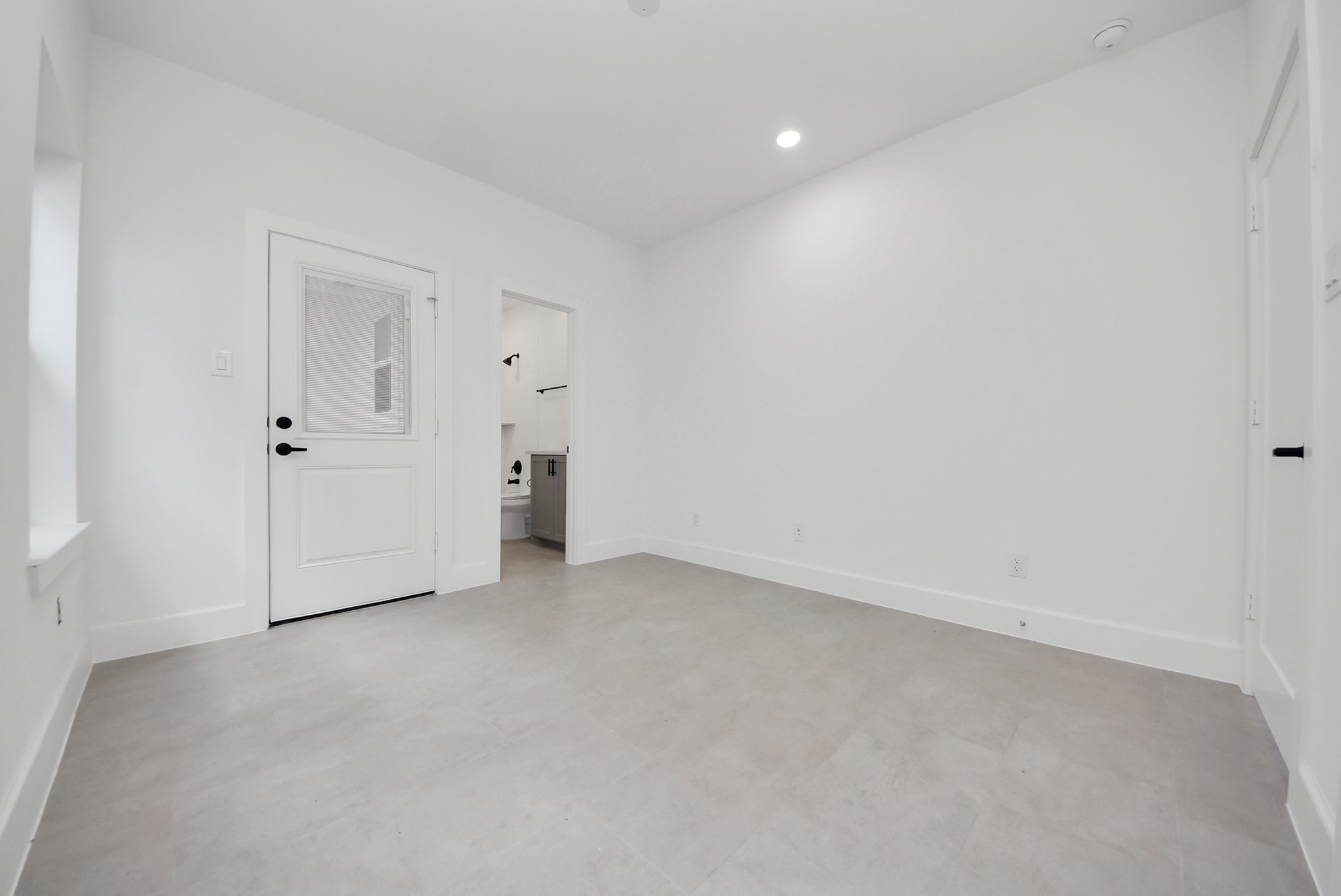 923 Fisher Street, Unit A Houston, TX 77018 - Photo 35 of 47 Here is a bright, minimalist utility or mudroom area, with neutral-toned flooring and white walls. Convenient access to the outdoors and an adjacent bath or laundry area makes it both stylish and functional.
