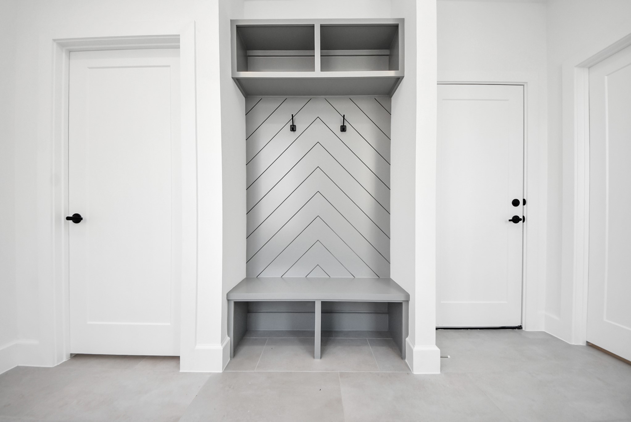 923 Fisher Street, Unit A Houston, TX 77018 - Photo 4 of 47 A smart mudroom solution tailored for modern lifestyles, complete with a built-in bench, chevron-detail backdrop, hanging hooks, and open shelving—designed for seamless organization and daily ease.