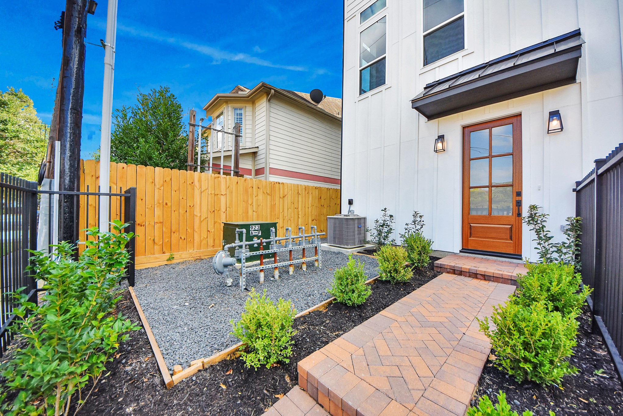 923 Fisher Street, Unit A Houston, TX 77018 - Photo 42 of 47 This contemporary exterior highlights clean lines and thoughtful landscaping. The driveway and gated entry provide a welcoming first impression, complementing the modern neighborhood surroundings.