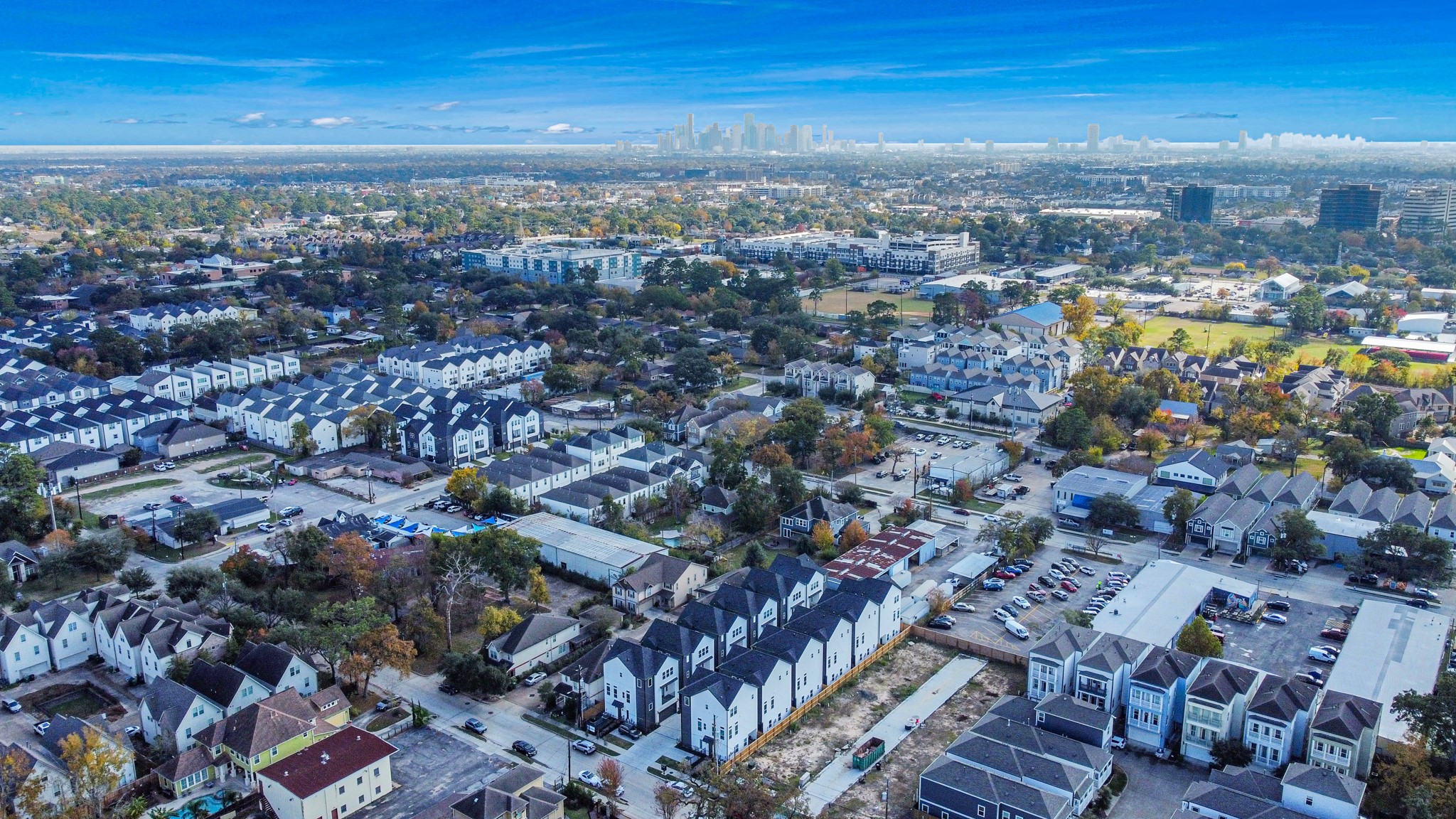 923 Fisher Street, Unit A Houston, TX 77018 - Photo 46 of 47 From above, the aerial view captures a vibrant suburban community, combining modern townhouses and homes with tree-lined streets. Its proximity to the city skyline shows the perfect blend of suburban calm and urban access.